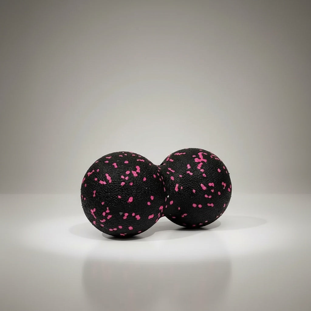 black and pink textured, peanut shaped ball with a neutral background.